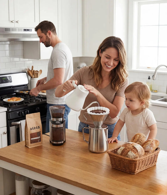 Smiling mother brewing a large batch of fresh coffee for her family using the 900ml AGOGO brushed stainless steel pour over dripper in a warm, modern home kitchen.