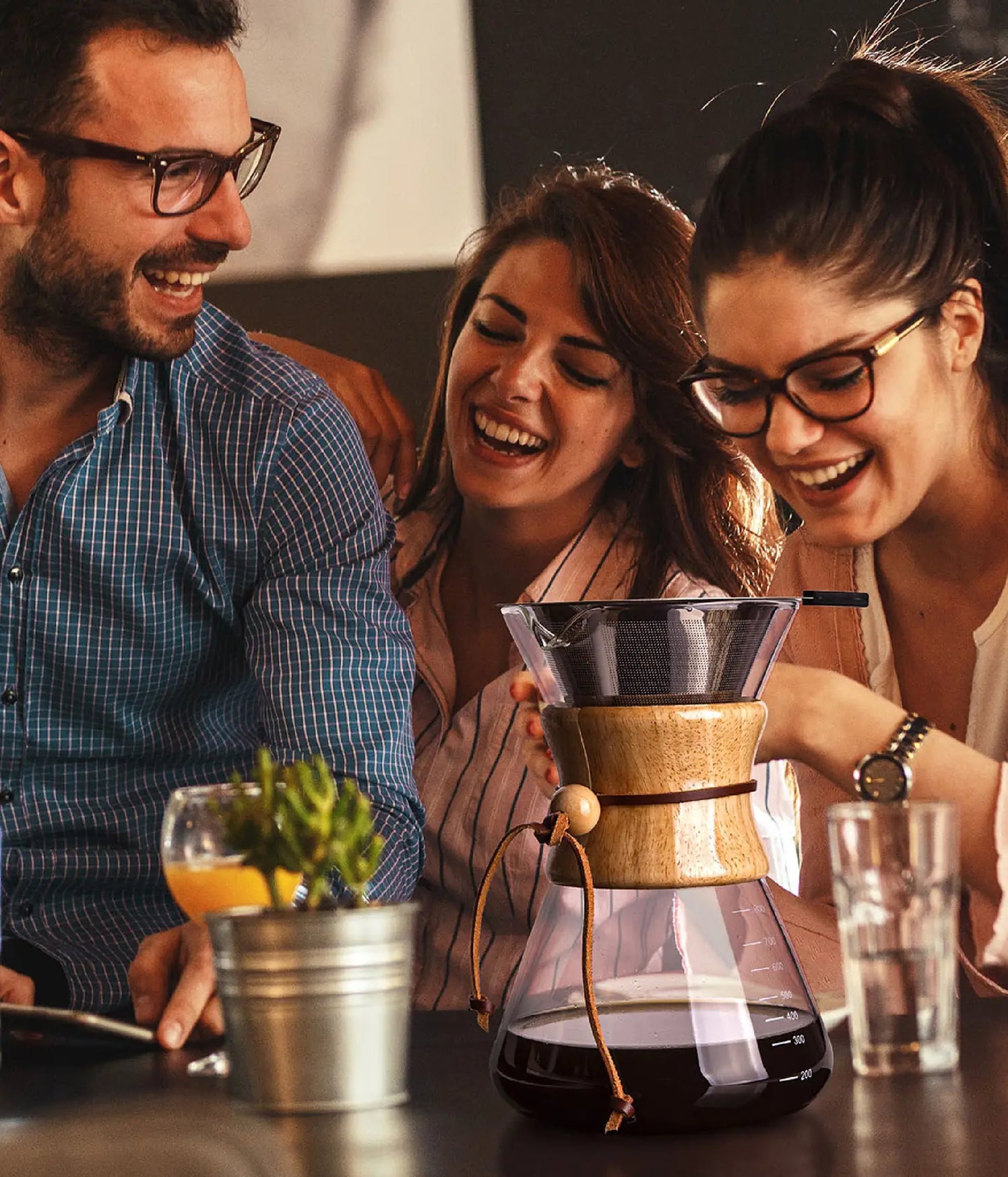 Friends laughing and sharing a fresh brew around a table, featuring the elegant AGOGO 800ml slim glass pour over coffee maker.