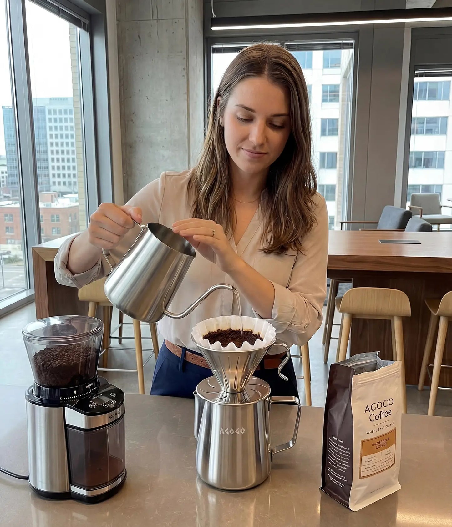 Professional woman preparing a fresh clean brew with the high-capacity 900ml AGOGO brushed stainless pour over maker in a bright modern office, ideal for team sharing.