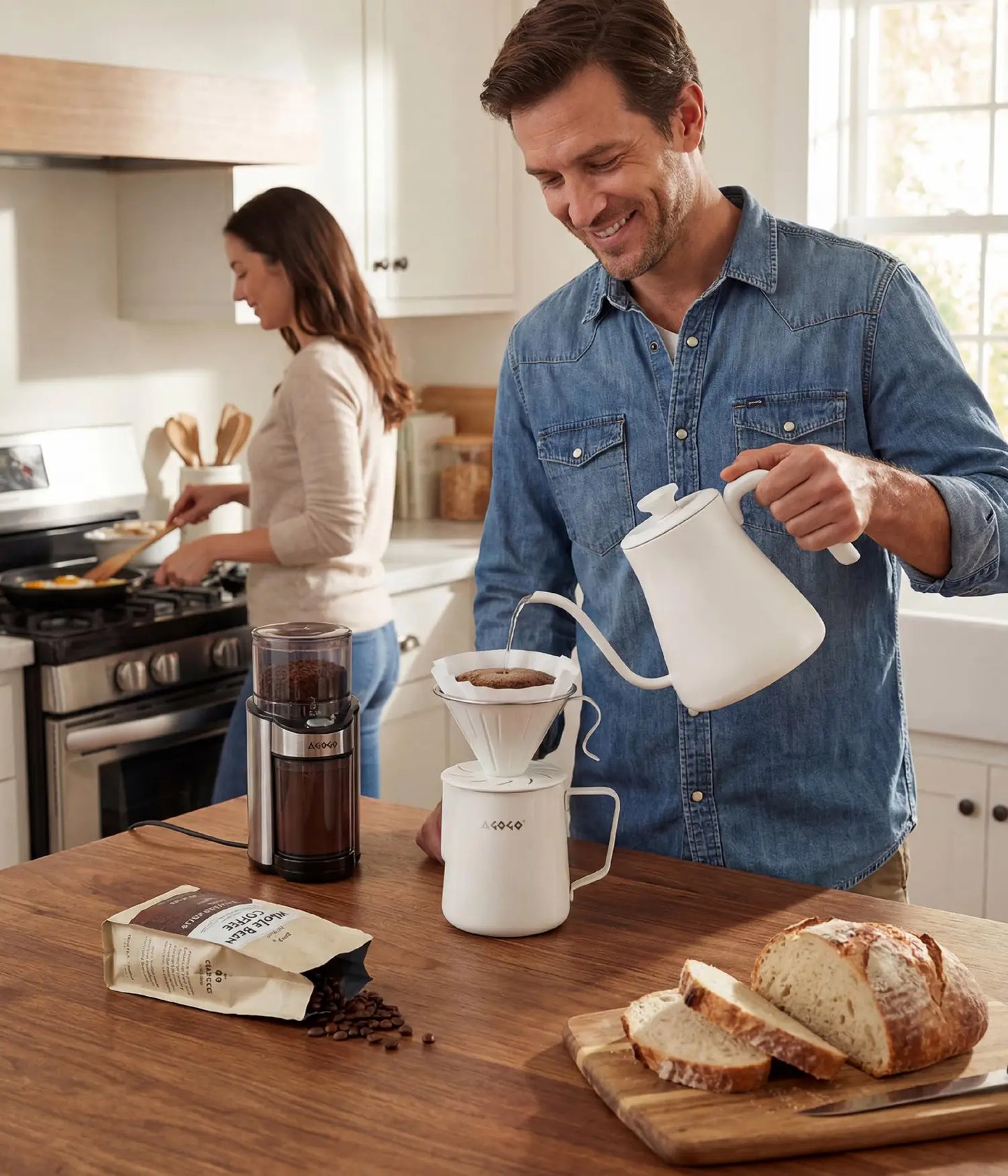 Man brewing a large batch of fresh coffee for his family using the elegant 900ml AGOGO warm cream stainless steel pour over dripper in a bright, modern home kitchen.