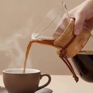 Step 4: Holding the AGOGO thermal glass carafe by its heat-resistant wooden collar to serve a freshly brewed perfect cup of coffee.