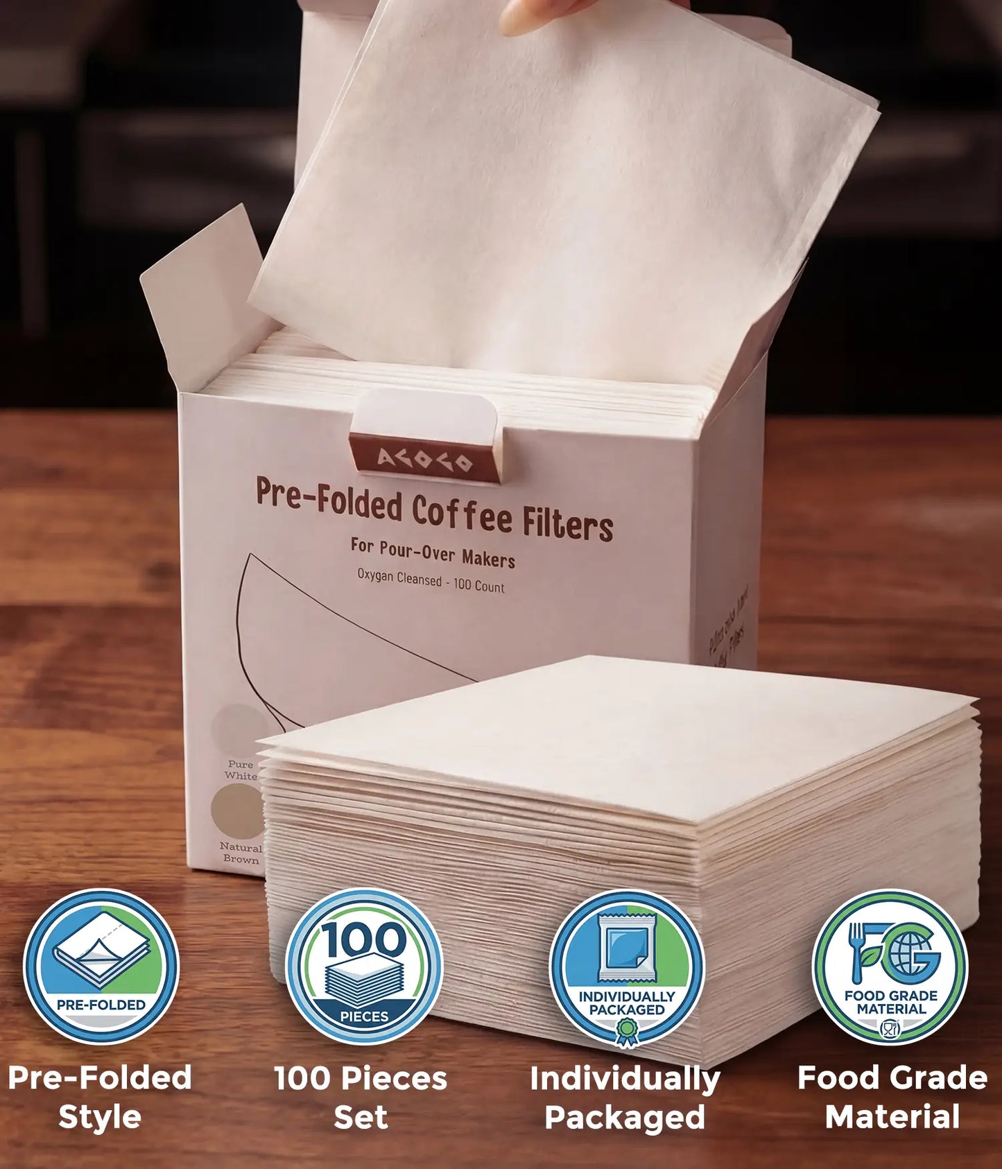 A hand taking a pure white square coffee filter from the AGOGO 100-count value box, with a stack of oxygen-cleansed pre-folded filters resting on a wooden table.