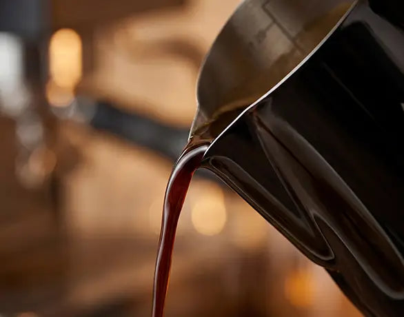 Close-up of rich, dark coffee pouring smoothly and steadily from the precision eagle-beak spout of the AGOGO black stainless steel coffee maker, ensuring zero spills.