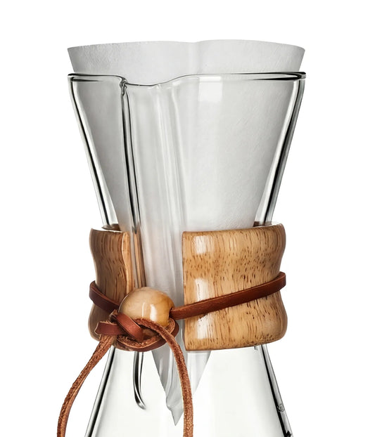 A pristine white, pre-folded AGOGO paper coffee filter placed perfectly inside a slim-neck glass pour-over coffee maker with a wooden collar.