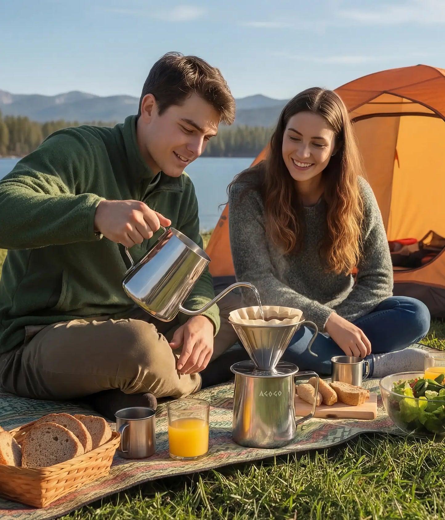 Happy couple enjoying a lakeside camping trip, brewing morning coffee by their tent with the unbreakable AGOGO brushed stainless steel pour over coffee maker.