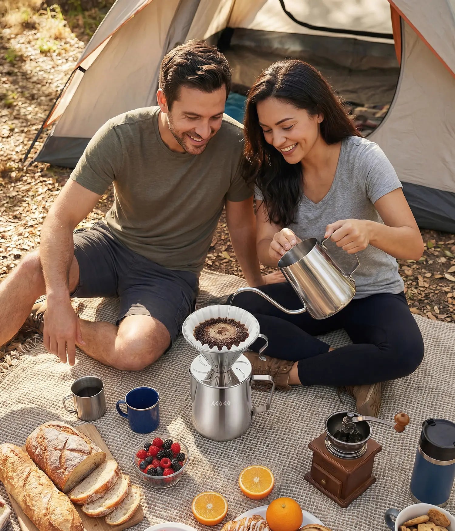 Happy couple enjoying a forest camping trip by their tent, brewing fresh morning coffee with the rugged, large capacity 900ml AGOGO brushed stainless steel pour over maker.